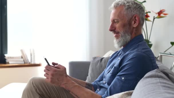 Ősz hajú középkorú hipster férfi alkalmi ing segítségével smartphone — Stock videók