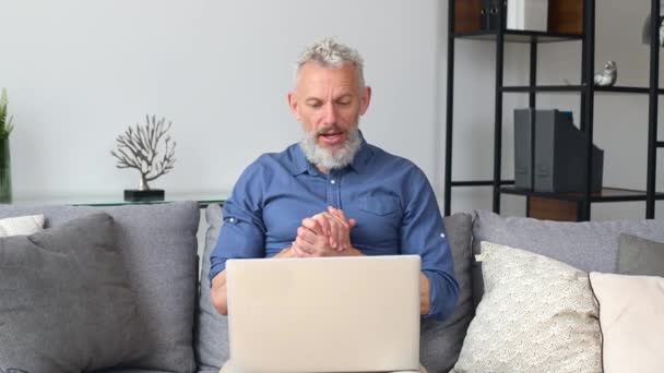 Homem idoso alegre moderno usando laptop para conexão de vídeo — Vídeo de Stock