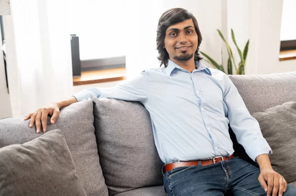 Χαρισματικός μελαχρινός Ινδιάνος με κομψό casual ντύσιμο κάθεται στον καναπέ — Φωτογραφία Αρχείου