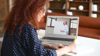Kıvırcık kız öğrenci çevrimiçi eğitici webinar izliyor