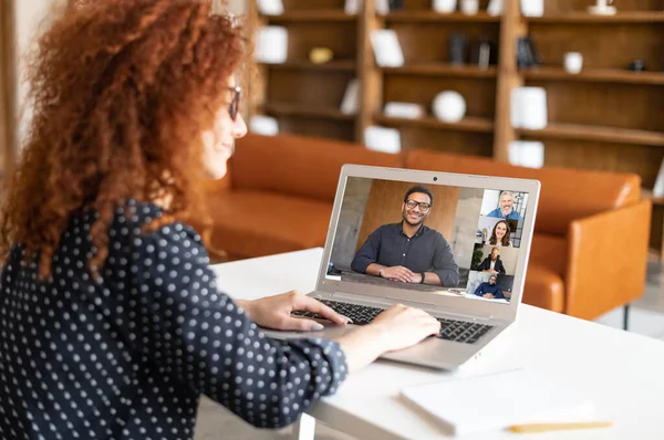 Curly vrouw praten met diverse gemotiveerde workteam op de laptop scree — Stockfoto