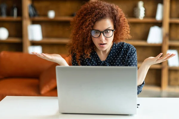 Femme entrepreneur rousse perplexe et confus regardant l'écran de l'ordinateur portable — Photo