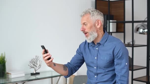 Empresário em desgaste casual inteligente está usando smartphone para conexão de vídeo — Vídeo de Stock