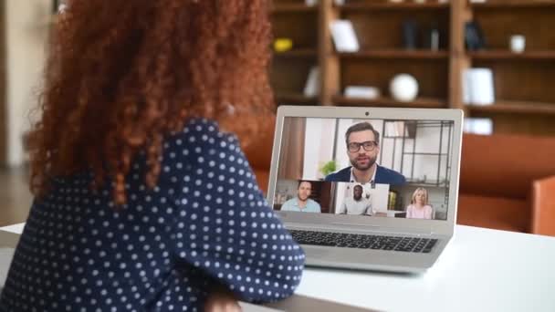 Zadní pohled kudrnaté žena mluví s různými motivovanými workteam na obrazovce notebooku — Stock video