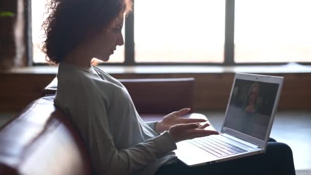 Mujer que utiliza la aplicación para la comunicación de vídeo a distancia con una colega — Vídeo de stock