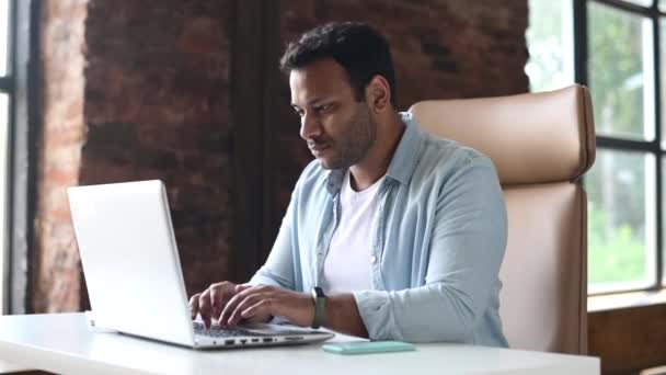 Веселый современный молодой индийский бизнесмен смотрит на экран ноутбука с радостью кричит — стоковое видео