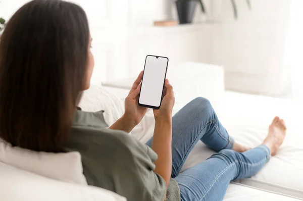 Indian woman holds smartphone with a blank empty screen