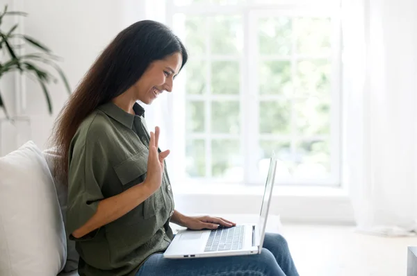 Positieve slimme jonge indiase vrouwelijke freelancer met behulp van laptop voor video call — Stockfoto