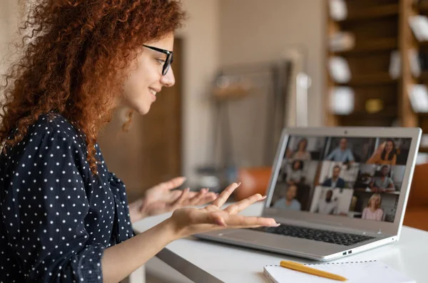 Smiling female freelancer or business owner with curly hair using app for distance video communication — Fotografia de Stock