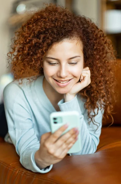 Junge rothaarige Frau plaudert am Telefon und lächelt breit — Stockfoto