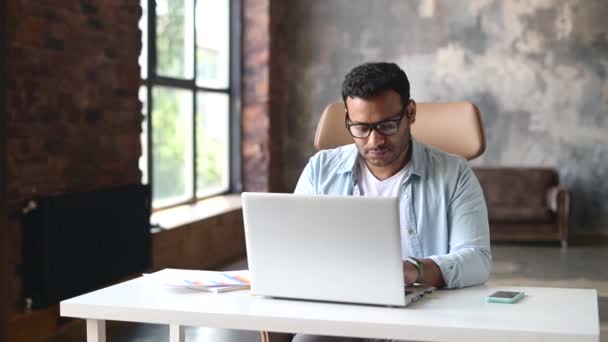 Empresario indio inteligente usando un portátil en la oficina — Vídeo de stock