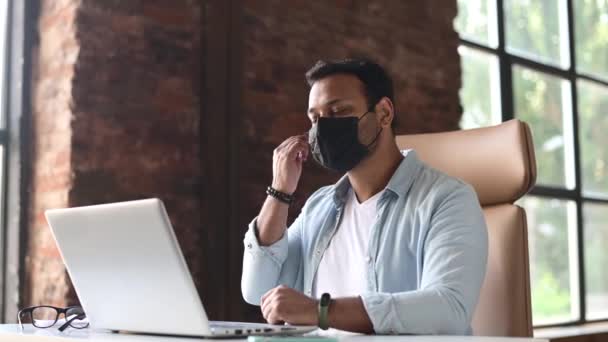 Alegre indiana masculino escritório empregado homem decolando médico máscara protetora — Vídeo de Stock