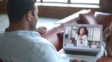 Hintli bir adam iş arkadaşlarıyla video iletişimi için bilgisayar uygulaması kullanıyor