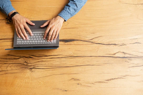 Male hands typing on the keyboard, top view