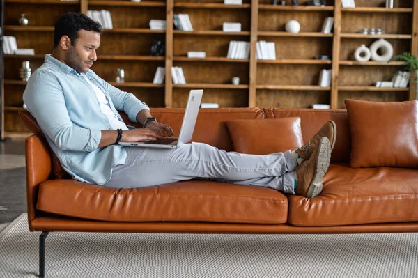 Young indian man spends home leisure with a laptop — Stock Photo, Image