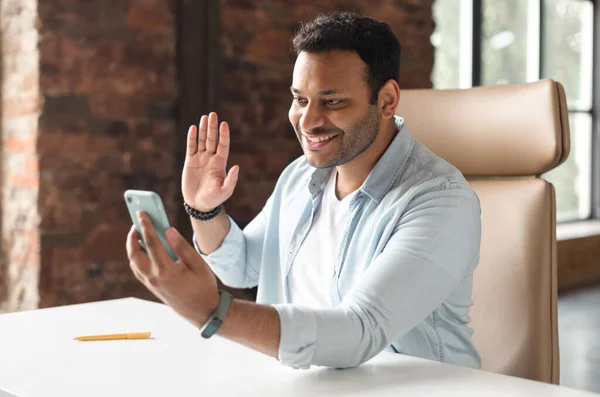 Hombre indio en ropa casual utilizando la aplicación de teléfono inteligente para la comunicación virtual —  Fotos de Stock