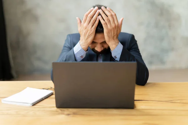 Estresado joven empresario indio tocando la cabeza y se siente mareado — Foto de Stock