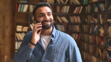 Mutlu Hintli erkek küçük işletme sahibi akıllı telefondan konuşuyor.