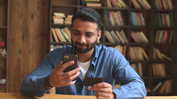 Młody przystojny indyjski freelancer człowiek za pomocą smartfona dla płatności online — Wideo stockowe