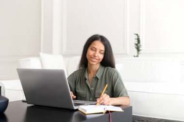 Evden uzakta çalışmak için bilgisayarını kullanan serbest çalışan bir kadın..