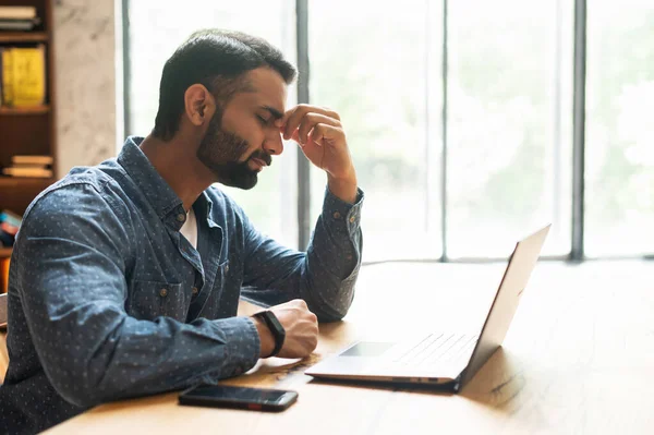 Exhausted middle eastern entrepreneur tired from online work