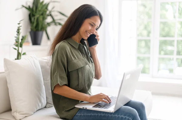 Smiling young indian woman using laptop computer for remote work from home