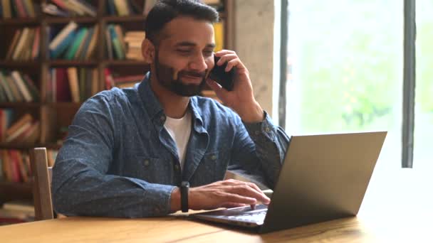 Ofisinde çalışan orta yaşlı Hintli bir adam, akıllı telefon kullanıyor. — Stok video