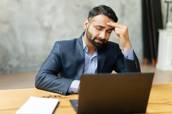 Molesto empresario indio en traje formal tiene fuerte dolor de cabeza — Foto de Stock