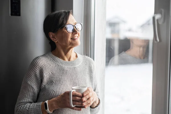メガネをかけた年配の女性のクローズアップポートレートはモーニングコーヒーを楽しむ — ストック写真