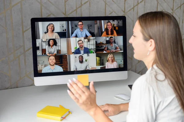 Бізнес-леді використовує додаток на ноутбуці для відеозв'язку з багатьма людьми — стокове фото