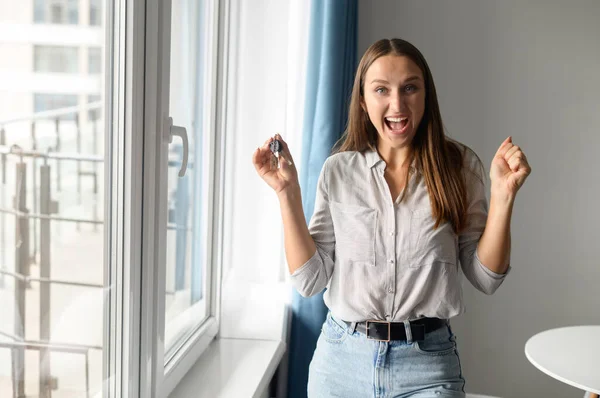 기쁨에 넘치는 행복 한 젊은 여자가 새로운 집 열쇠를 들고 있다 — 스톡 사진