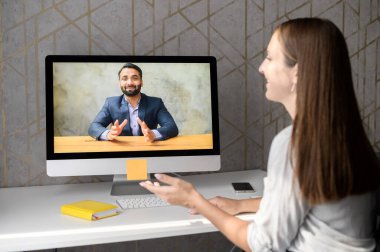 Genç bir kadın internetten Hintli bir adamla konuşuyor.