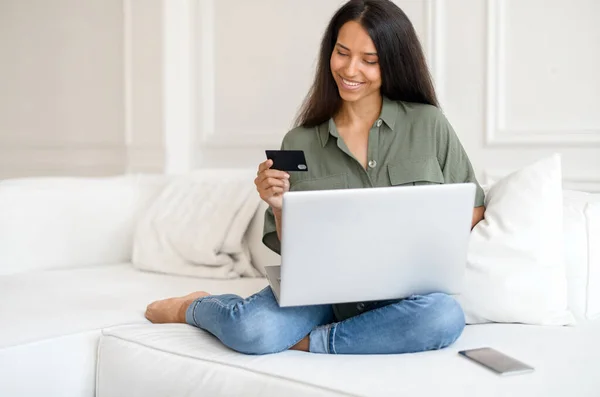 Vidám fiatal indiai nő online vásárlás hitelkártyával és laptoppal — Stock Fotó
