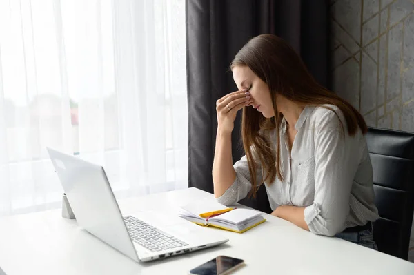 Molesto mujer preocupada estresada sentado en frente de la computadora portátil, sosteniendo puente de la nariz —  Fotos de Stock