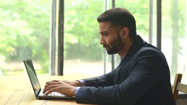 Seriös säker ung indian man entreprenör i formell kostym som arbetar på en bärbar dator — Stockvideo