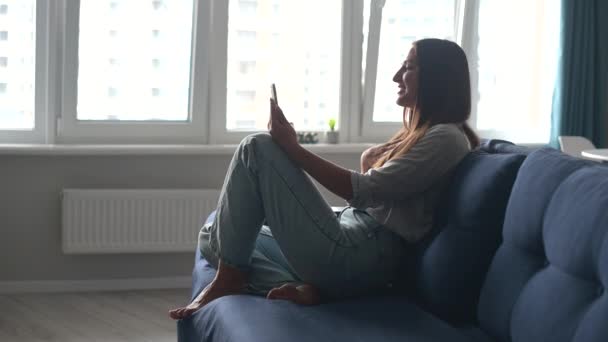 Mulher alegre usando smartphone moderno para conexão de vídeo — Vídeo de Stock