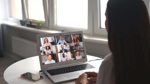 Mujer joven que utiliza la aplicación informática para la comunicación de vídeo con diversos grupos — Vídeos de Stock