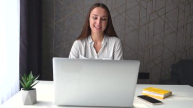 Genç bayan serbest çalışan video araması için dizüstü bilgisayar kullanıyor