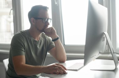 PC kullanan kararlı genç sakallı iş adamı ya da serbest çalışan