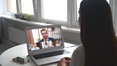Laptop ekranındaki kadın ve çeşitli ekip video aracılığıyla konuşuyor ve tartışıyorlar.