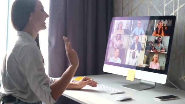 Junge Frau winkt und grüßt, spricht mit Kollegen, Mitarbeitern online — Stockvideo