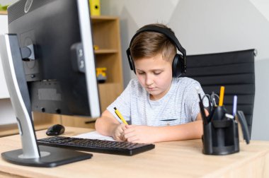 İlkokul erkek öğrencisi uzakta okuyor.