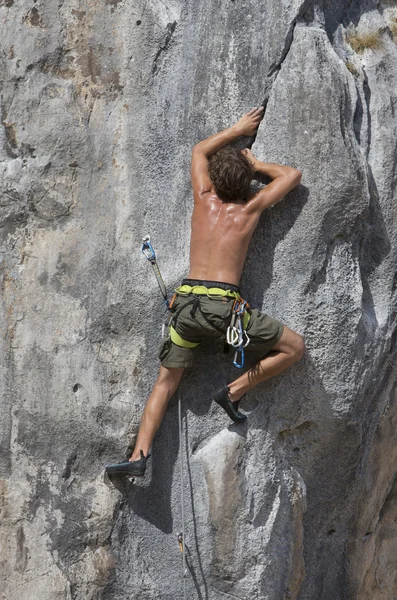 Homem escalando uma rocha — Fotografia de Stock