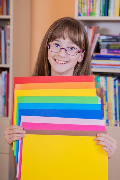 Schoolgirl  holding colored papers — Stock Photo, Image