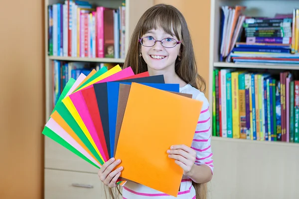 Schoolgirl  holding colored papers — Stock Photo, Image