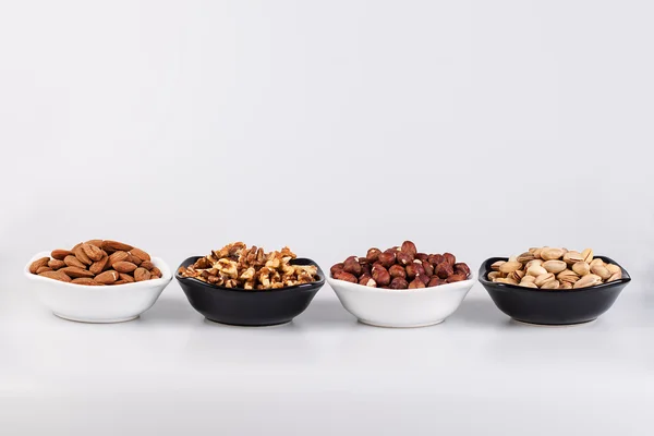 Assorted nuts in ceramic bowls — Stock Photo, Image