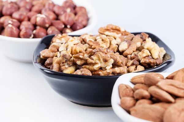 Assorted nuts in ceramic bowls — Stock Photo, Image