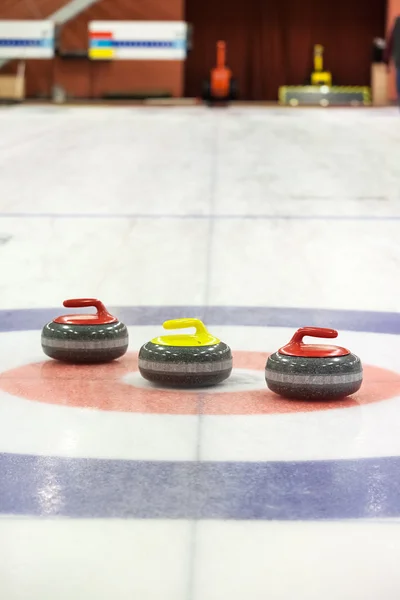 Curling rochas no gelo Fotografias De Stock Royalty-Free