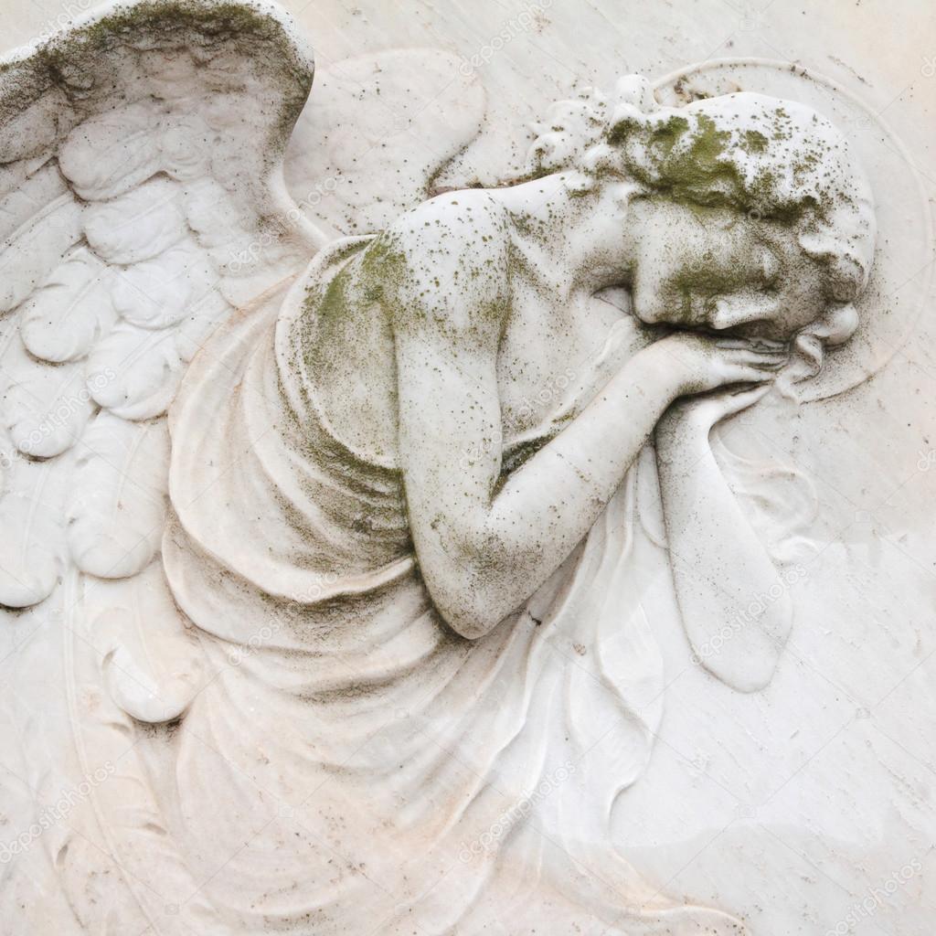 closeup of antique angelic relief on tombstone