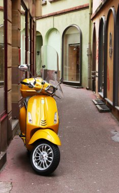 Küçük bir sokakta sarı moped